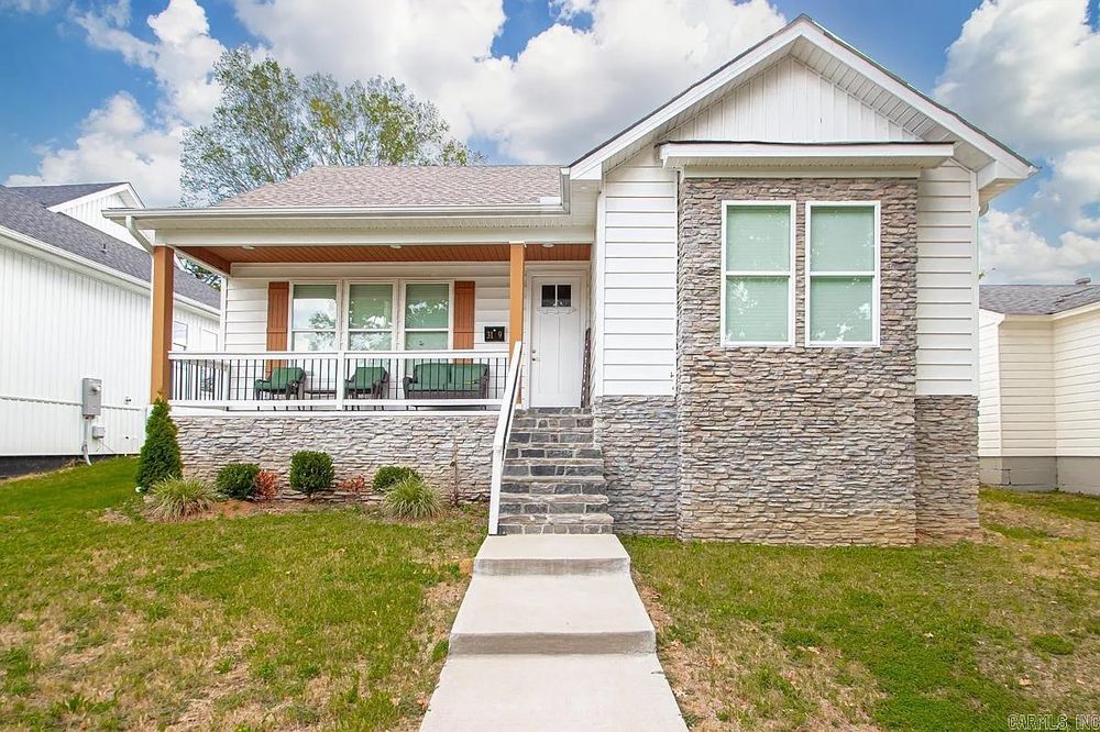 Bungalow with a stone veneer skirt and covered front porch