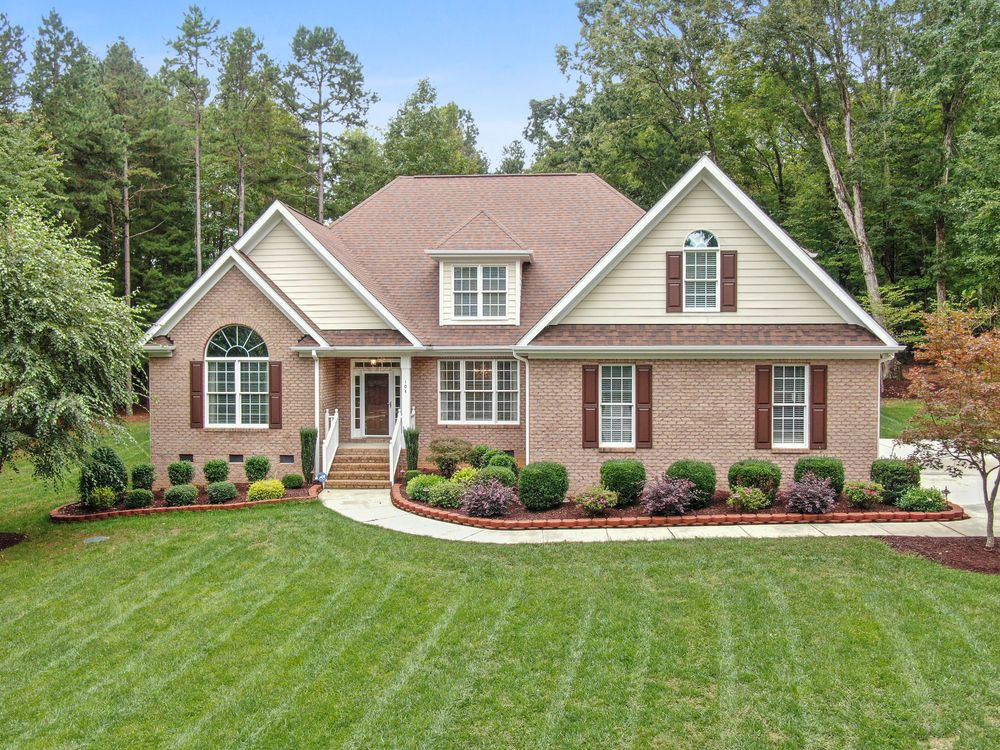 Home with brick and cream siding exterior in a wooded Little Rock neighborhood