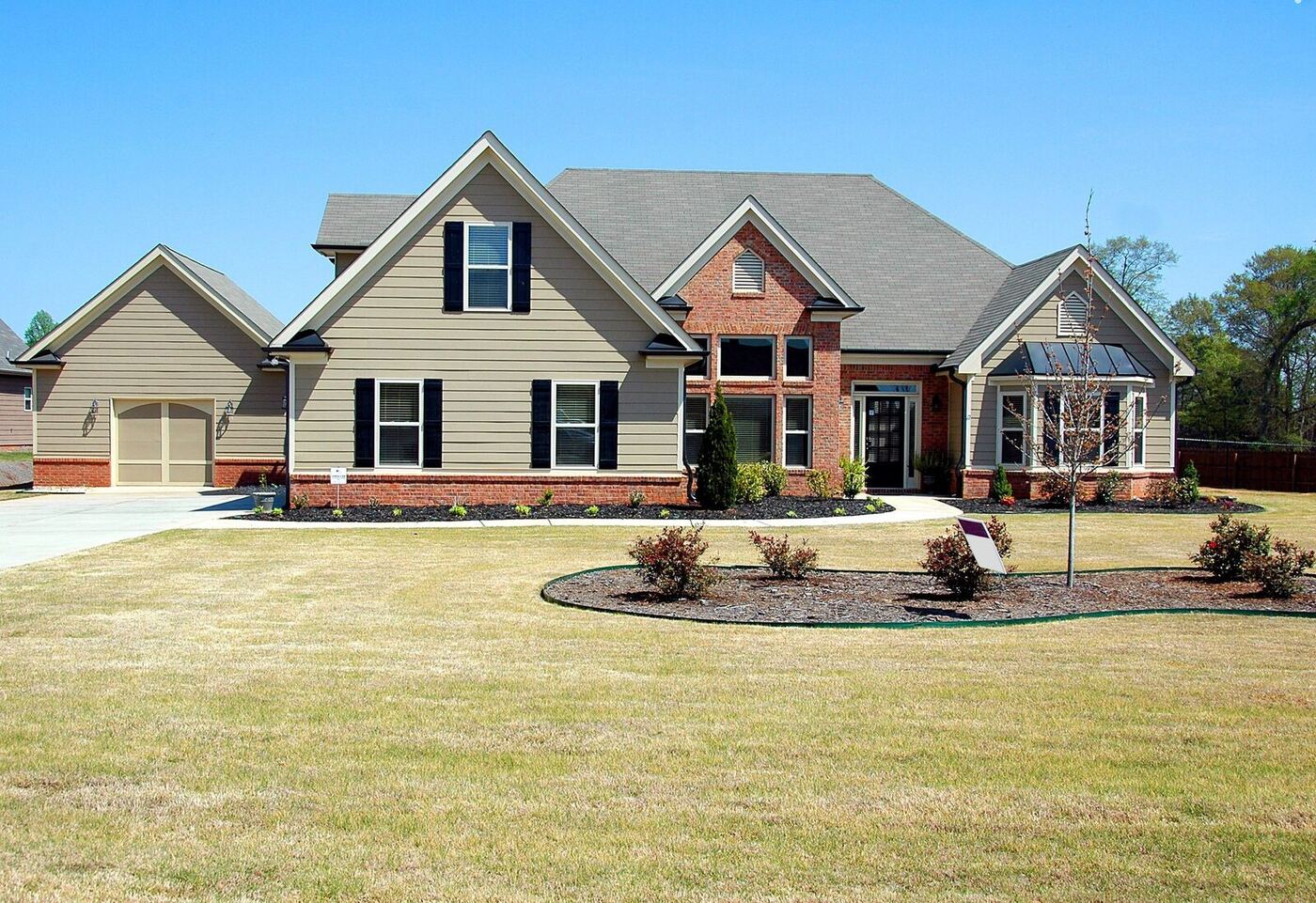 Elegant suburban home with freshly installed siding and a well-kept lawn