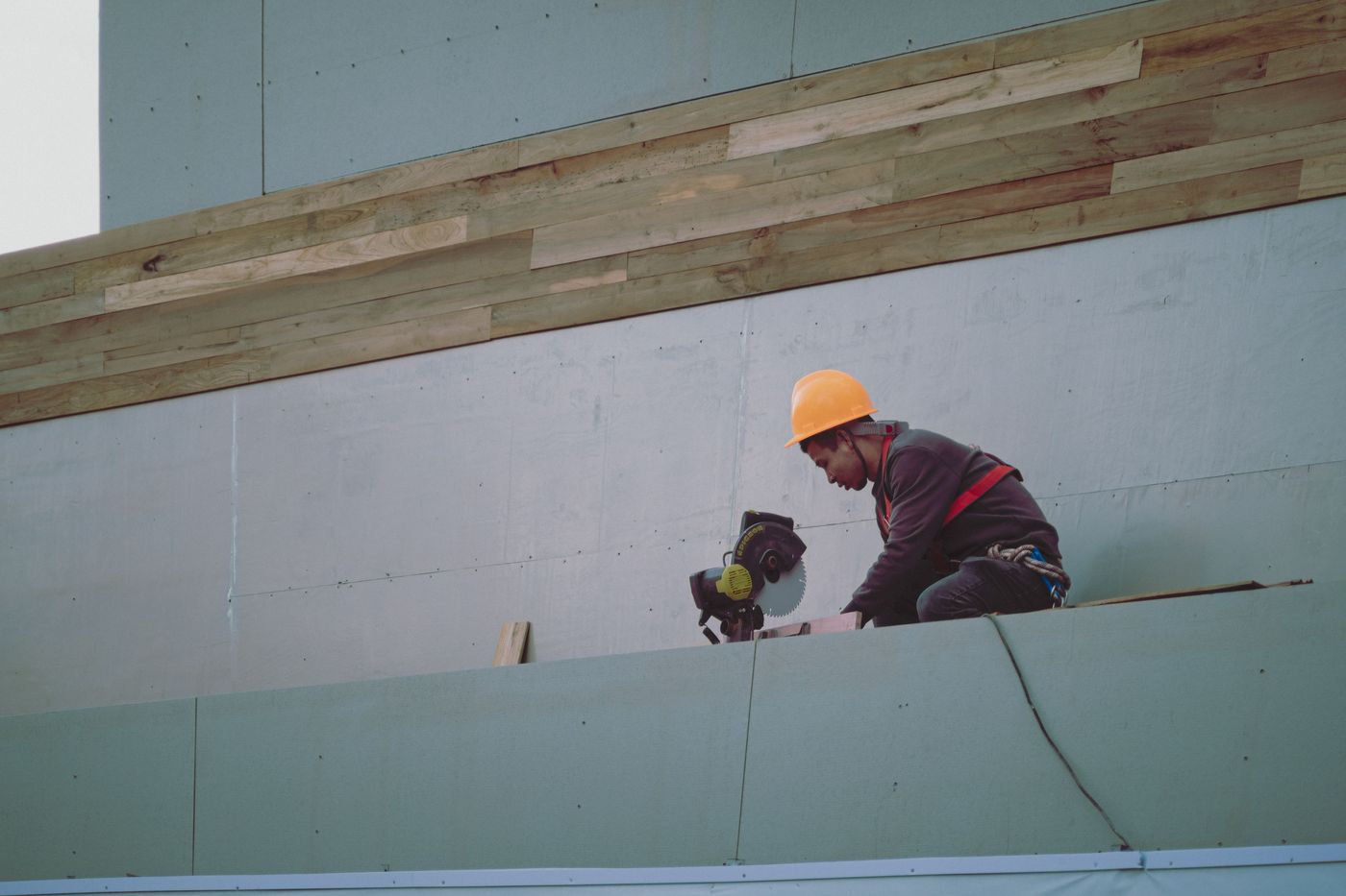 Crew member installing new siding cladding on a home exterior