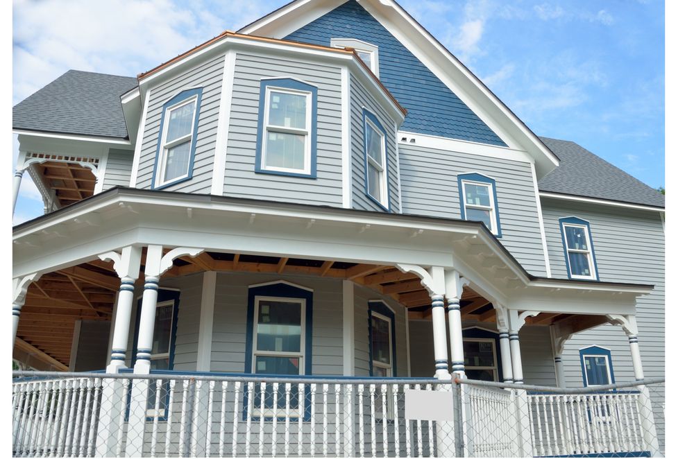 Home under construction with exposed framing during a siding installation