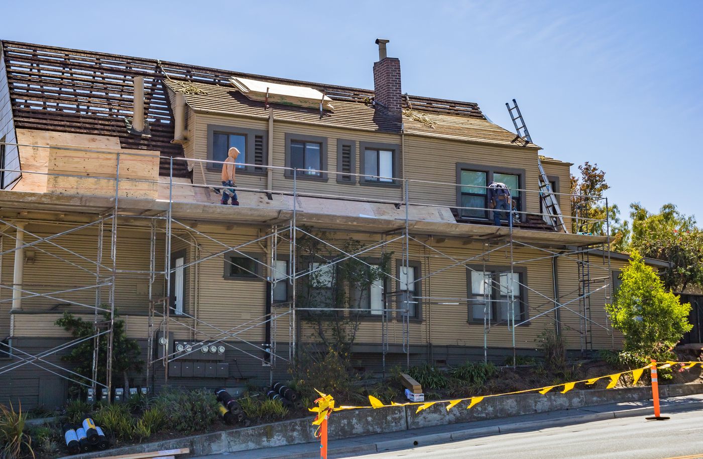 Crew working on scaffolding during a full siding replacement