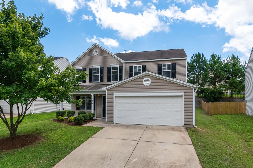 Two-story home finished with tan vinyl siding